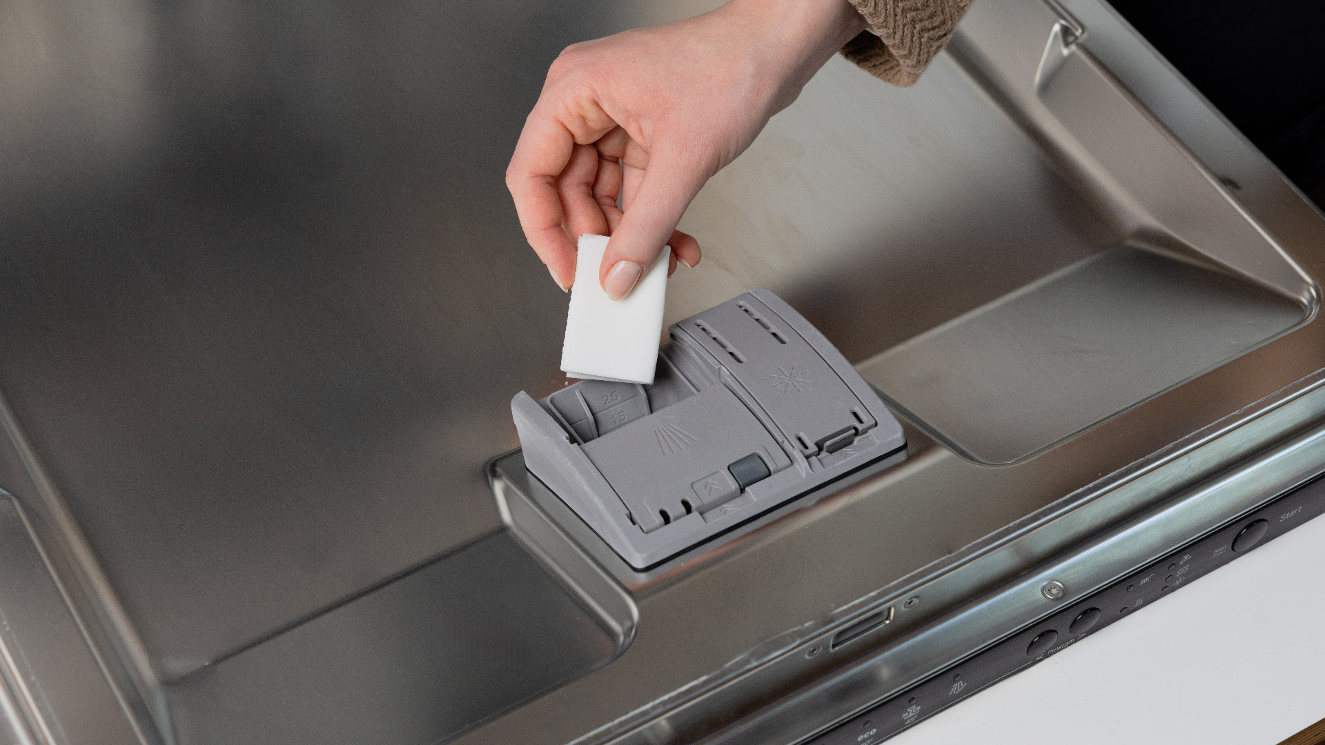Placing a Dip dishwasher sheet into the detergent dispenser